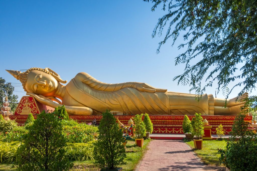 Golden Reclining Buddha in gardens at Wat Pha That Luang Vientiane Laos