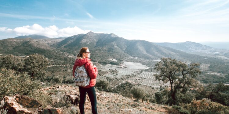 Woman with backpack traveling alone in mountains in Spain, Catalonia
