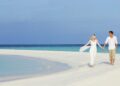 Romantic Beach Getaways: Couple Walking On A White Sandbar (Source: Canva)