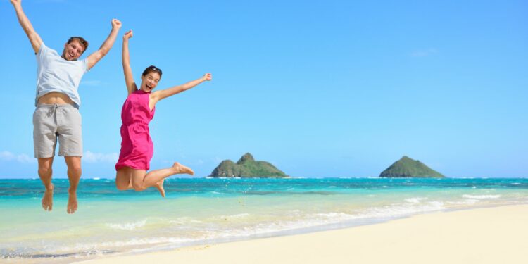 A couple jump shot to one of the best Secret Beaches (Source: Canva)