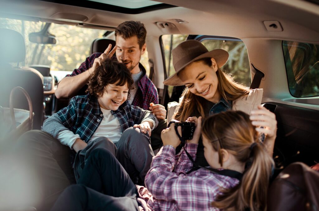 Taking Pictures On A Family Road Trip (Source: Canva)