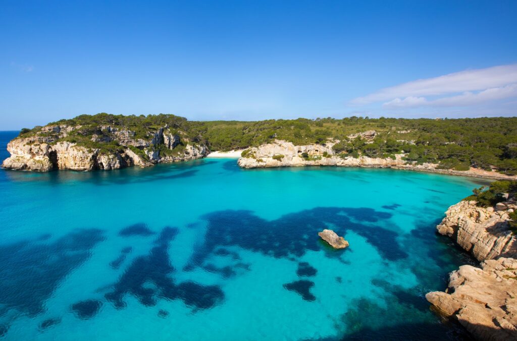 Scenic view of Cala Macarella beach in Menorca, Spain with turquoise water