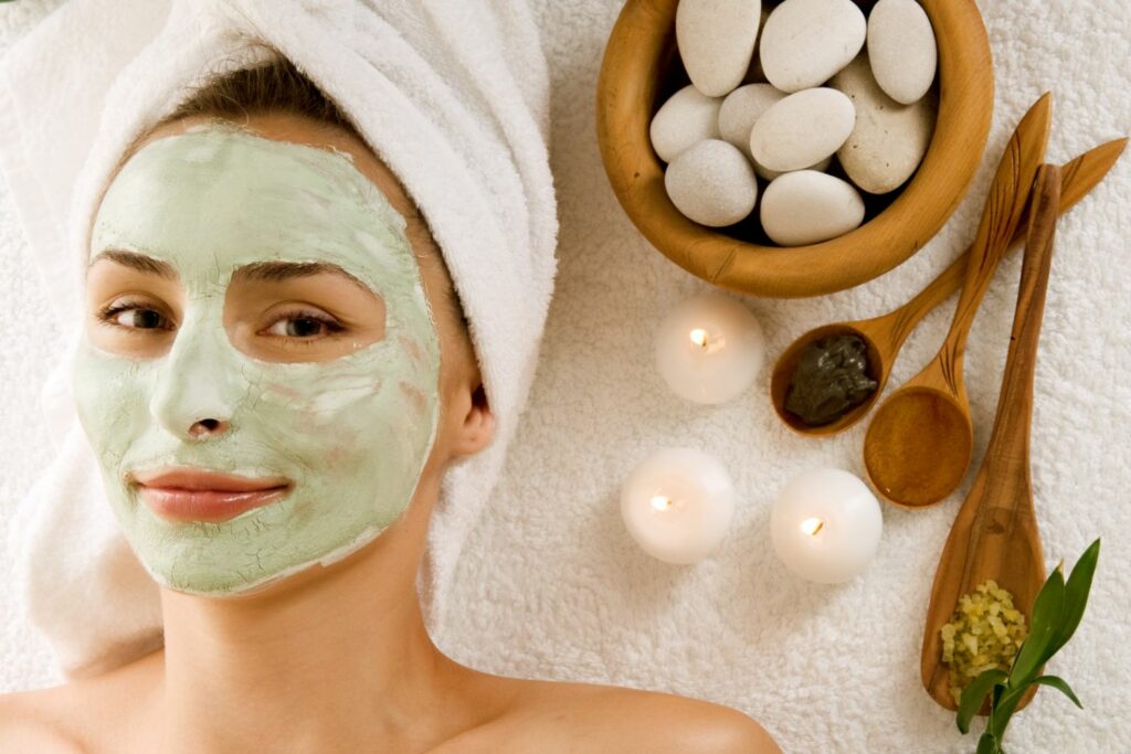 Woman receiving natural spa facial treatment with green mask
