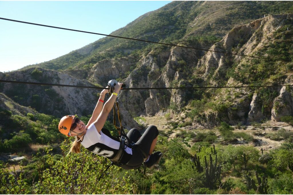 Young Woman Ziplining With A Mountain Background (Source: Canva)