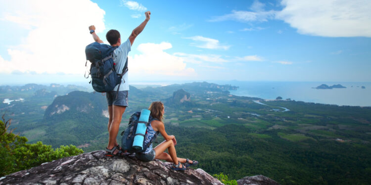 happy backpackers on mountain peak relishing the benefits of hiking