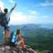happy backpackers on mountain peak relishing the benefits of hiking