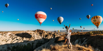 joyful couple among cappadocia hot air balloons, one of the best places to visit in turkey