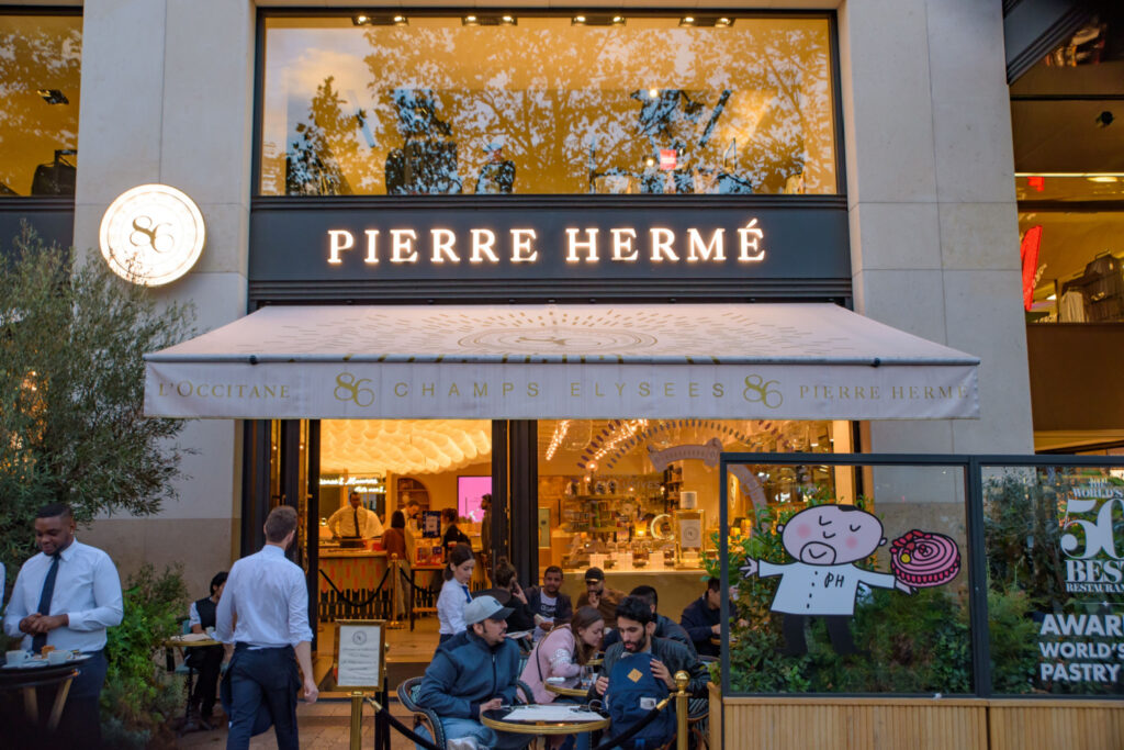 People in front of Pierre Hermé dessert store in Paris, France