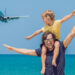 father and son on beach, celebrating father's day with plane landing