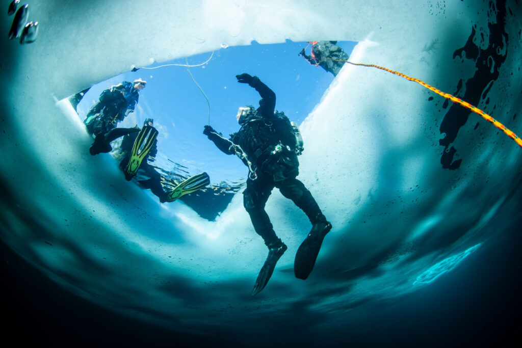 3 men exploring the depths with winter ice diving and adventure sports equipment