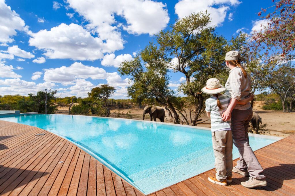 luxury safaris: mother and child enjoy wildlife near swimming pool on vacation