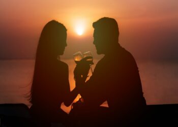 Silhouette of couple in love drinking wine during romantic dinner at sunset on the beach- Romantic Things to Do in Atlanta