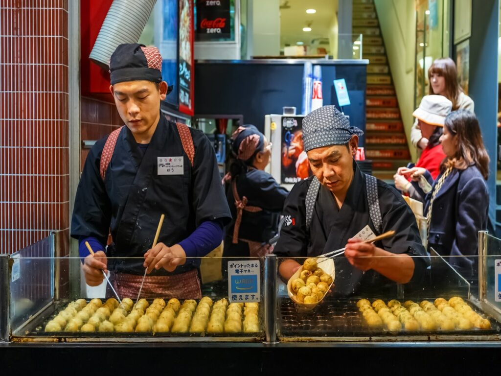 cooking takoyaki - food tour in osaka