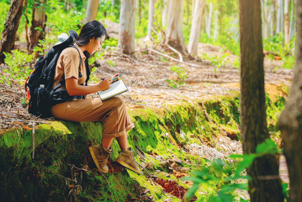 young woman hiker studying trail notes: hiking with a purpose