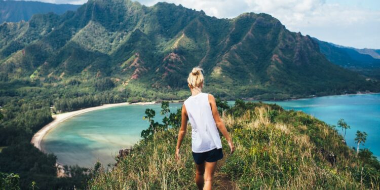 Blonde hiker looks over the ocean on a classic Hawaiian hike - Unique Things to Do in Maui