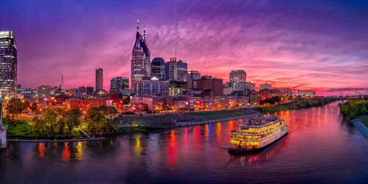 A breathtaking view of the colorful Nashville skyline at night, reflecting in the tranquil waters of Cumberland River. The city's lights create a mesmerizing display, and couples often come here to enjoy the romantic atmosphere.