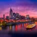 A breathtaking view of the colorful Nashville skyline at night, reflecting in the tranquil waters of Cumberland River. The city's lights create a mesmerizing display, and couples often come here to enjoy the romantic atmosphere.