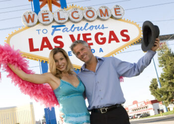 couple day trips from las vegas in front of the las vegas sign
