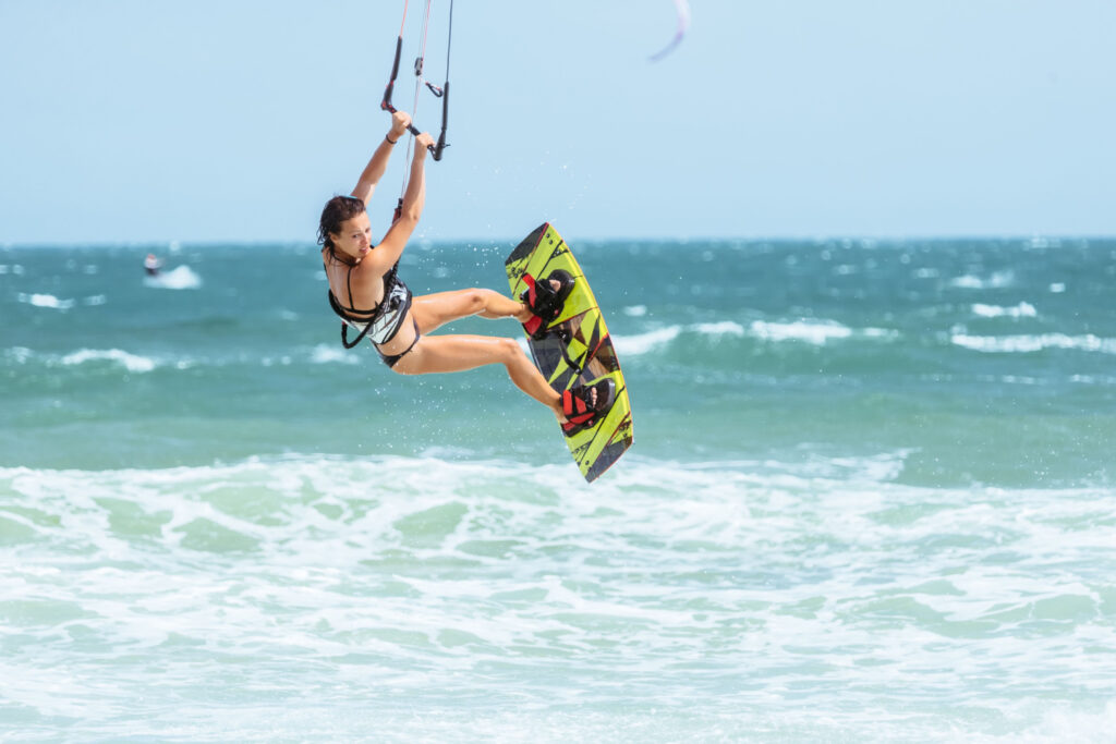 A female kite surfer rides the waves