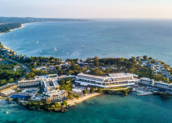 Aerial view of Negril, Jamaica, highlighting its beach, sunset, clear waters, and serene vacation allure