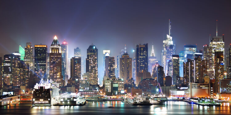 new york city skyline panorama at night over hudson river with reflections