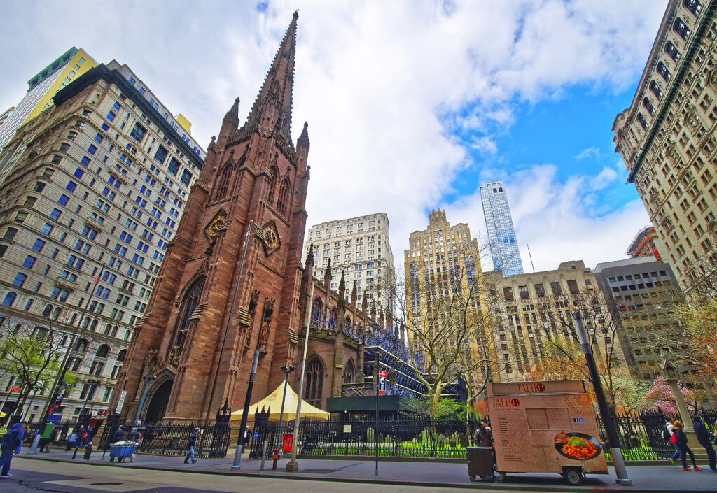 Street view of Trinity Church in Lower Manhattan, New York, USA. It is a historic parish church near Wall Street and Broadway. - Roman Babakin/Shutterstock