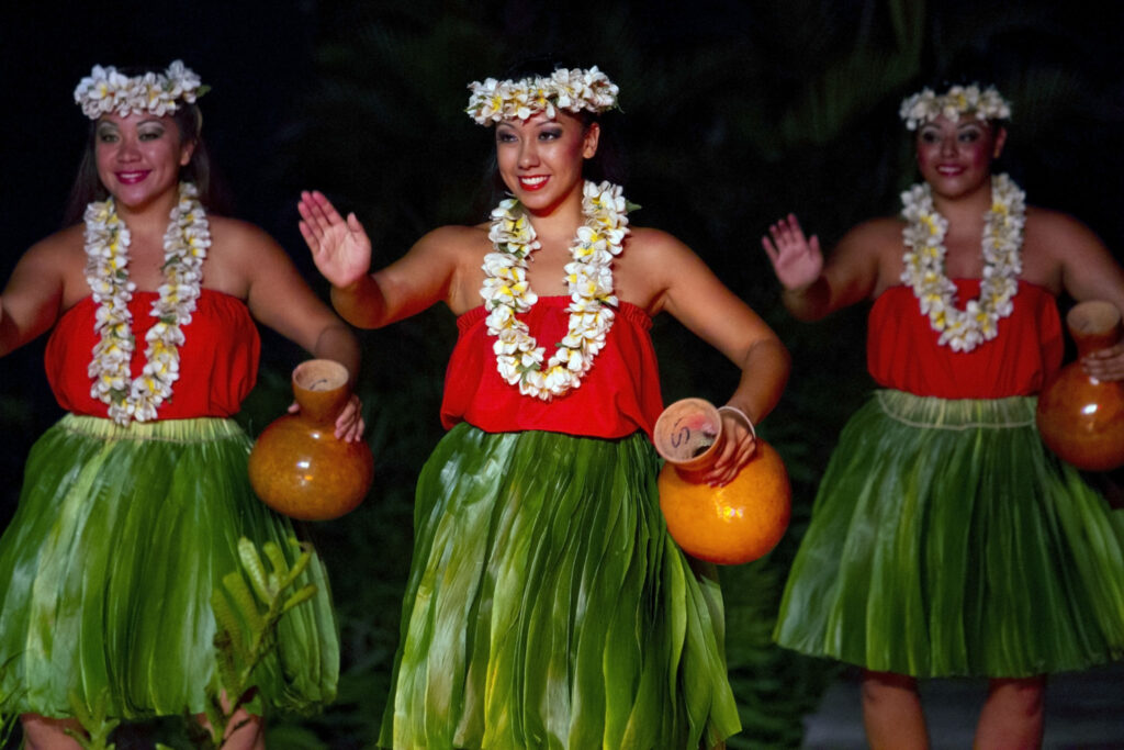 Women in traditional dress perform Hawaiian dance