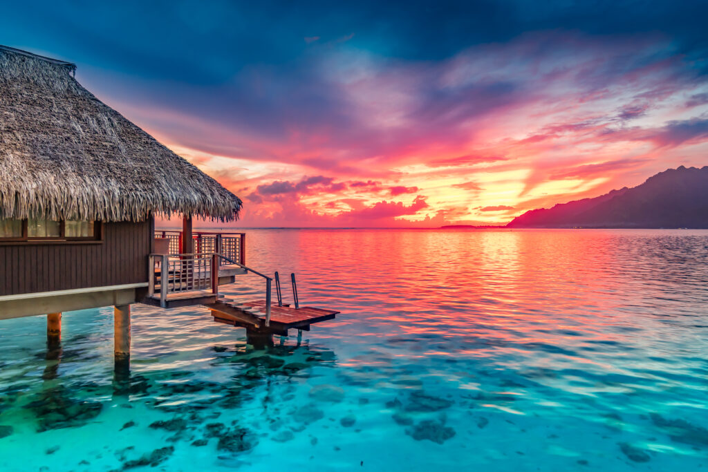 Stunning colorful sunset sky on the horizon of Moorea, the South Pacific Ocean.  NAPA/Shutterstock