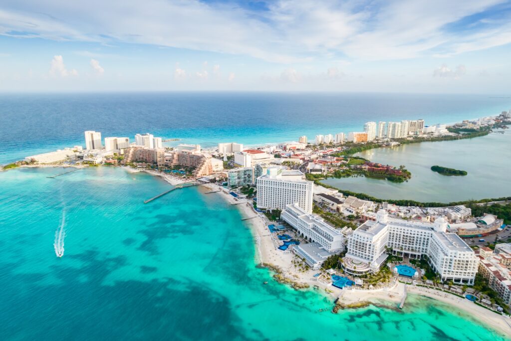 Aerial panoramic view of Cancun beach and city hotel zone in Mexico. Caribbean coast landscape of Mexican resort with beach Playa Caracol and Kukulcan road.   mariakray/Shutterstock