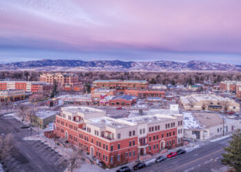 Aerial view of downtown Fort Collins, Colorado, with mountains in the background on a cold winter morning